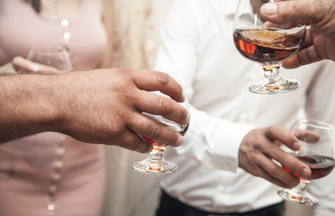 Hands of people with cognac.
