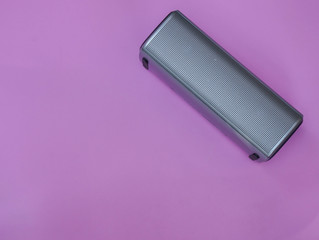 portable speaker on pink pastel background for music listening