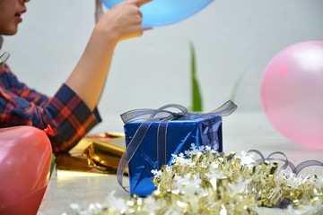 close up portrait of women hand holding red balloon and wrapping gift preparing birthday surprise party