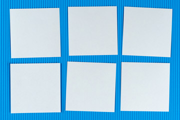 six white notes lying on blue corrugated cardboard. Concept reminder for guys or gays, schedule. Mock up, copy space, layout.