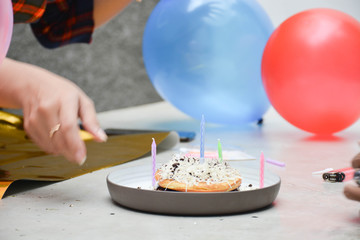 portrait of man and two's hijab woman preparing birthday surprise party on concrete table