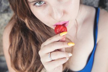 Girl eating strawberry.