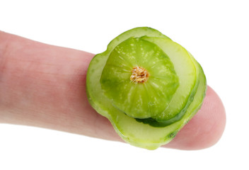 In the future we will eat this concept - small ugly bad  cucumber vegetable  slices  on finger isolated macro