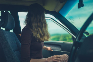 Fototapeta premium Young woman getting into her car