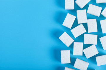 White cubes of shugar on blue background.