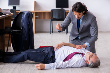 Male employee suffering from heart attack in the office