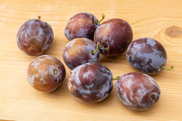 Fresh juice plums on a wooden background