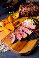 rustic medium butter beef steak with herbs and potato wedges