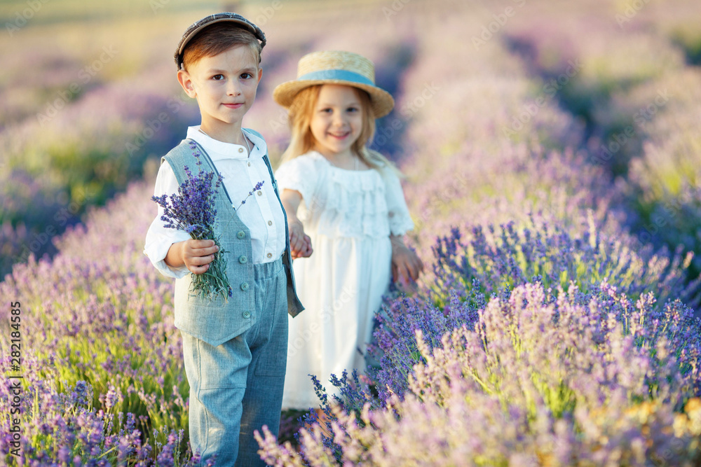 Wall mural children in the field with flowers.