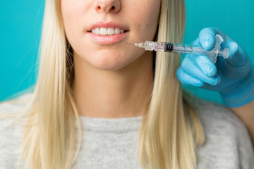 Doctor makes injections in woman's lips