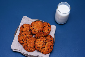 Chocolate breakfast cookies with a glass of milk on a turquoise table