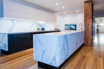 Modern open plan contemporary kitchen with marble island bench, countertops and back splash in...