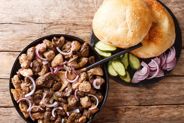 Jerusalem mixed grill or meorav Yerushalmi tasty chicken and offal fried with onions and spices close-up on a plate. horizontal top view