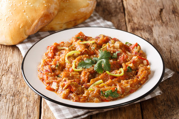 Delicious traditional Baingan Bharta eggplant, with tomatoes, garlic and spices close-up on a plate. horizontal