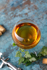White wine in a glass. The concept of winemaking. Place under your text. Still life on a textural background.