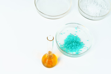 Colored liquids inside lab glassware on white table in laboratory
