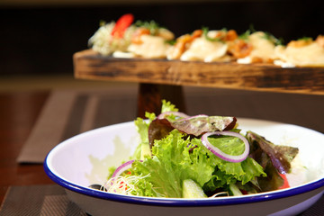 Dumplings with potatoes and greaves in sour cream on a wooden board and salad. Dumplings with potatoes and salad.