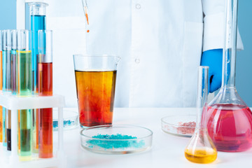 Manipulations with laboratory glass chemical containers on table