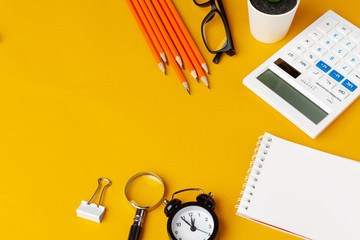 Stylish messy yellow desk top with various stationery top view