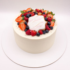 White cake decorated with berries.