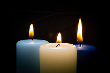 Fototapeta na wymiar Close up of three colorful wax candles flame
