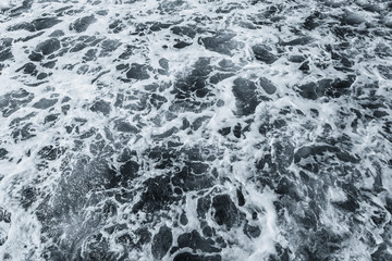 Fototapeta na wymiar Organic background of dark blue aqua sea water surface splashing outside. Horizontal colour photography.