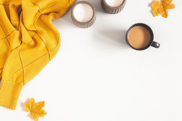 Autumn composition. Cup of coffee, yellow sweater on white background. Autumn, fall concept. Flat...
