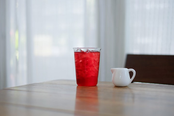 A glass of rose ice tea with syrub , relaxing drink on wooden table.  selective focus.