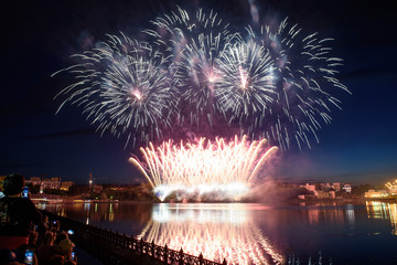 Beautiful pyrotechnic fireworks at night over the water. Celebration.