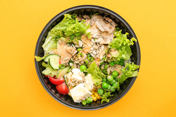 Container with delicious food on color background