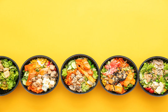 Many containers with delicious food on color background