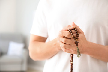 Religious man praying to God at home, closeup