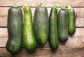 Fresh zucchini squashes on wooden background