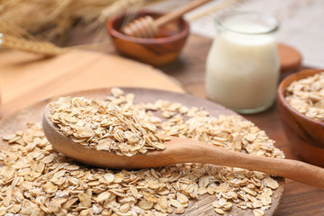 Spoon with oat flakes on plate, closeup