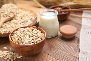 Bowl with oat flakes on wooden table