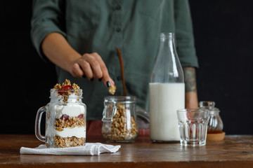 The glass of granola with dried berries and yogurt.