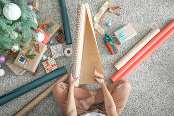 Woman making Christmas gift on floor, top view