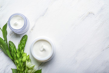 Jars of body cream on white background
