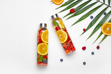Bottles of tasty infused water on white background