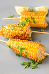Tasty grilled corn cobs on plate, closeup