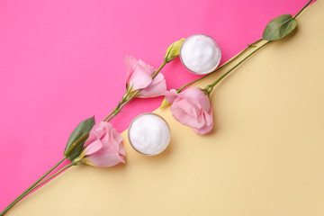 Obraz na płótnie Canvas Body cream with flowers on color background