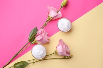 Obraz na płótnie Canvas Body cream with flowers on color background