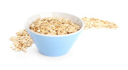 Bowl with raw oatmeal on white background