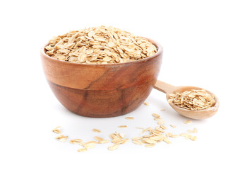 Bowl and spoon with raw oatmeal on white background