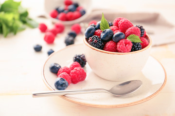 Bowl with tasty ripe berries on table