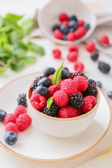 Bowl with tasty ripe berries on table