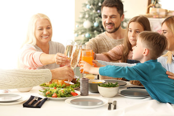 Happy family clinking glasses during Christmas dinner at home