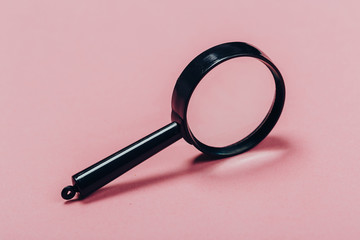 Small magnifying glass on pink background