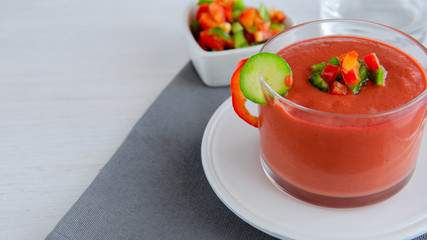 Gazpacho, tomato soup made from made of raw blended vegetables. Traditional Spanish cold soup on wooden table.Copy space