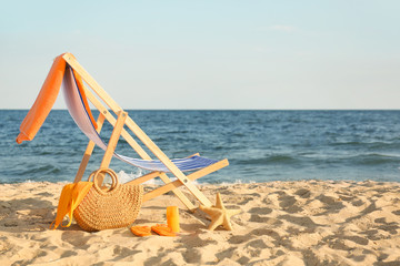 Fototapeta na wymiar Chair with bag and accessories on sand beach